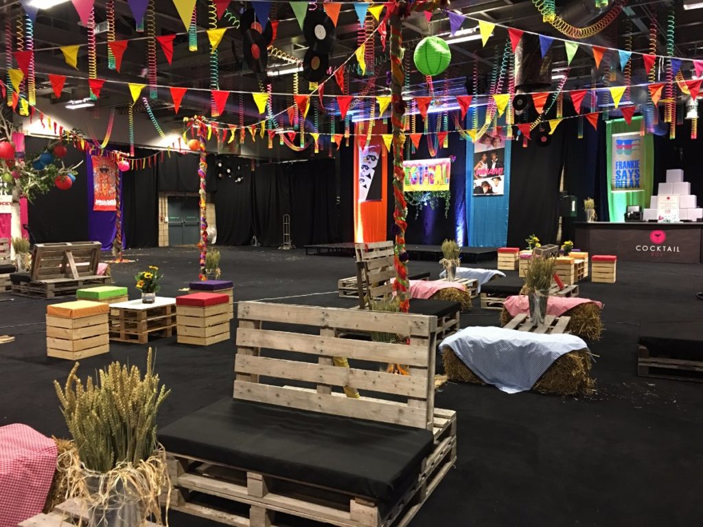 Eighties music festival themed event with wooden chairs and bunting