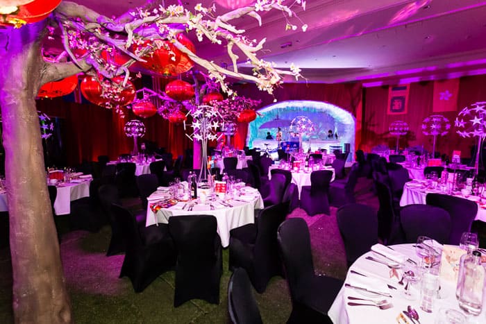 Around the world themed gala dinner artificial tree paper lanterns star table centres black chair covers
