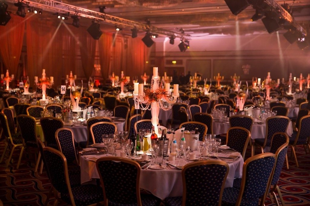 light up LED Candelabra table centres with gold curtain draping in the back ground