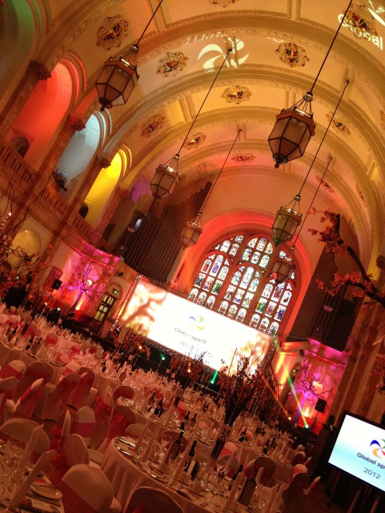 Event room with painted ceiling and hanging chandeliers, with dressed tables with tree twig table centres with hanging crystals