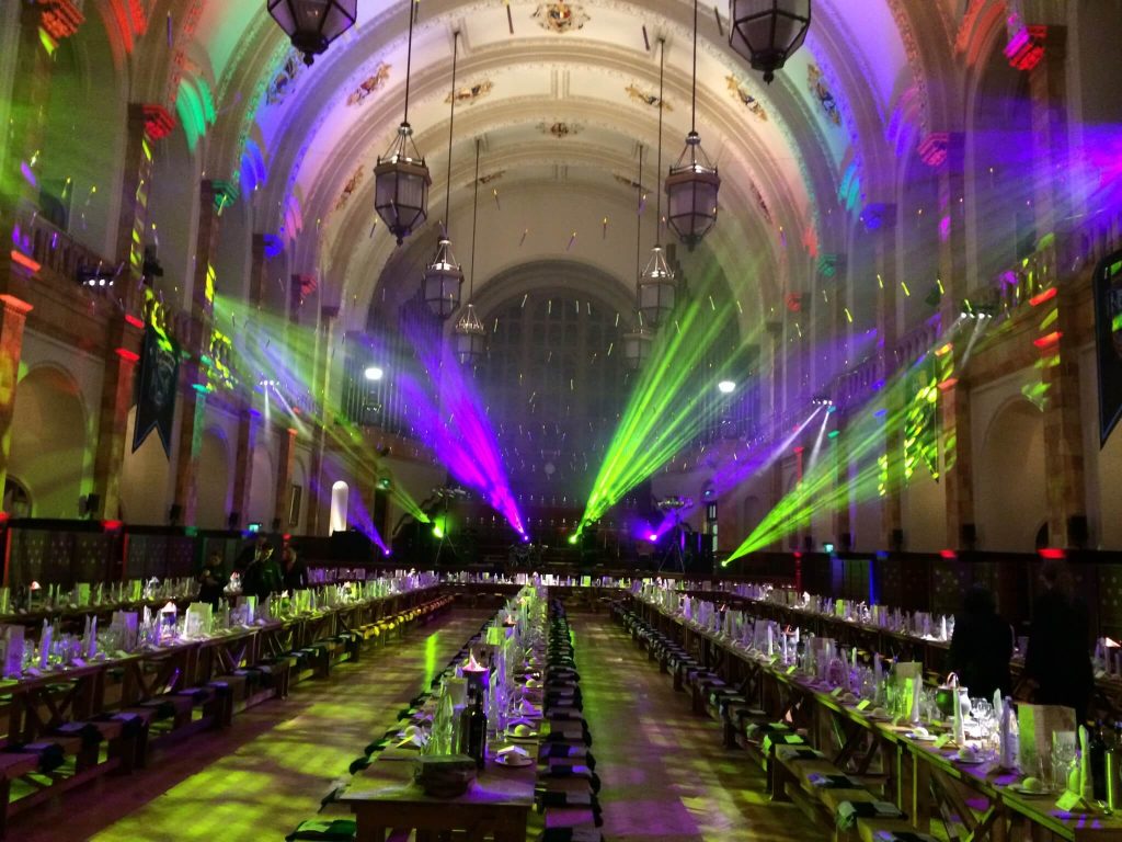 Harry Potter Theme grand harry potter themed dining hall with trestle tables and wooden benches like the film strob lighting to add a party vibes gala dinner