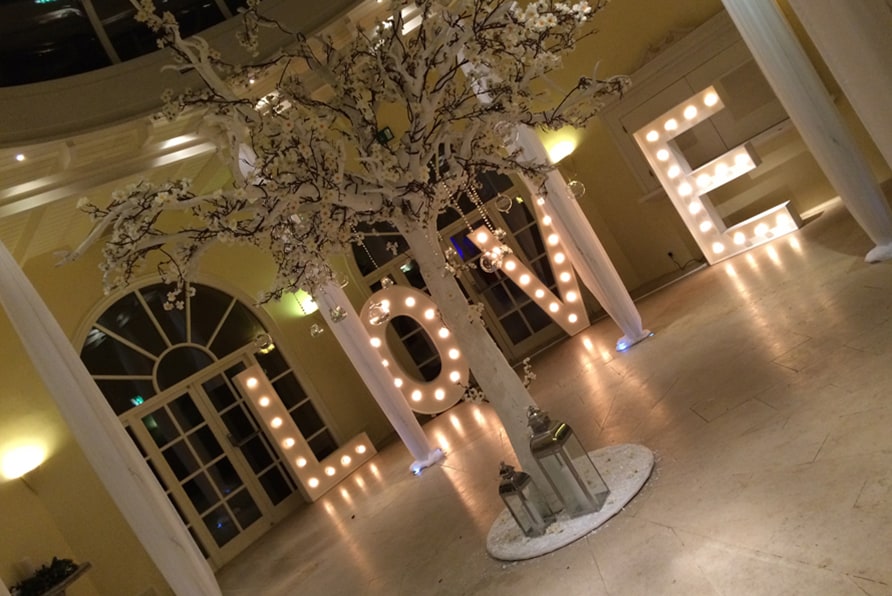 Winter artificial tree white with white blossoms with hanging glass candle and large light up LOVE sign