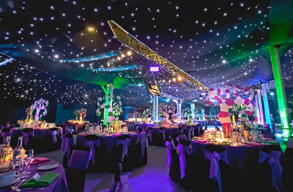 Willy Wonka inspired event theming with tree table centres starlight ceiling draping with purple colour scheme