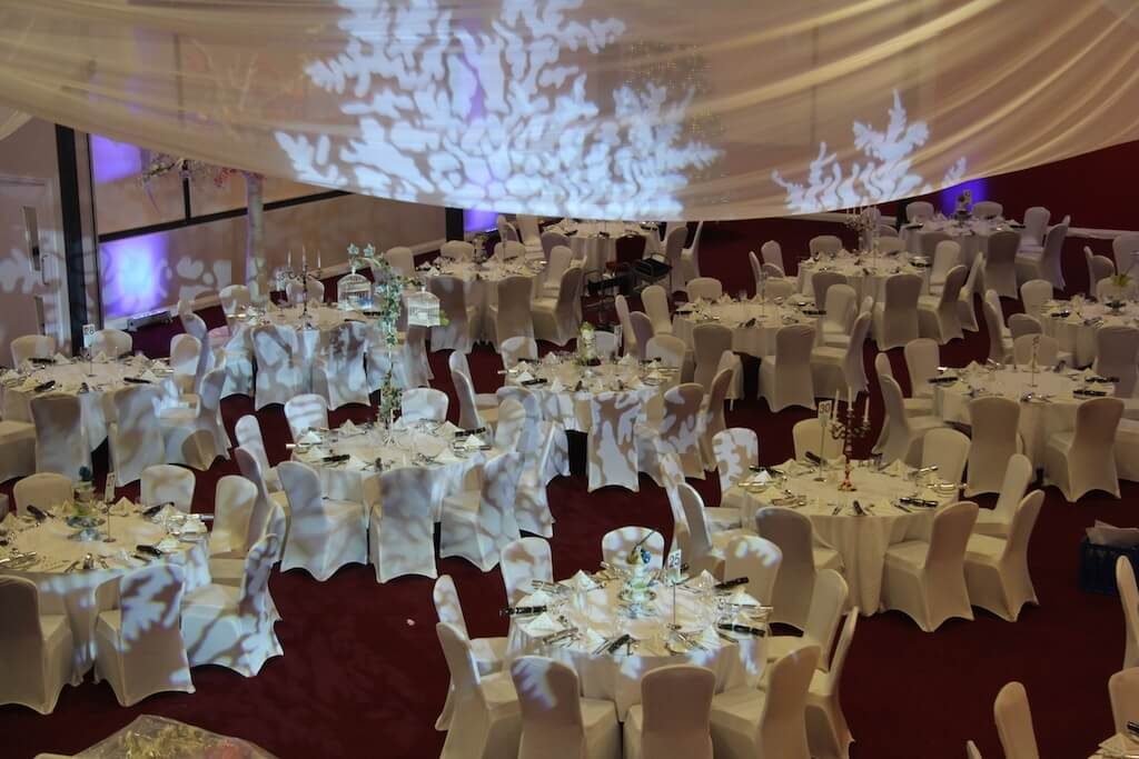 White tables and chairs white snowflake lights with white draping